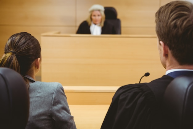 A panel of judges in a modern courtroom, listening intently to arguments. The focus is on their expressions, which convey a sense of seriousness and contemplation.