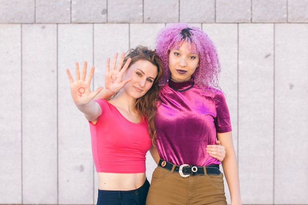 A paparazzi-style photo showing two individuals identified as managers of Ariana Grande and Billie Eilish having an animated discussion outside a recording studio. The photo is grainy and taken from a distance, adding to the sense of secrecy and intrigue.
