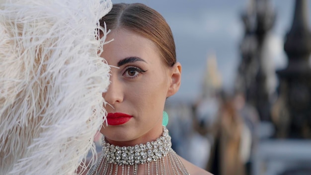 A close-up shot of a celebrity on the red carpet wearing a completely sheer gown. The gown is heavily embellished with intricate beadwork and sequins. She is posing confidently for the cameras.