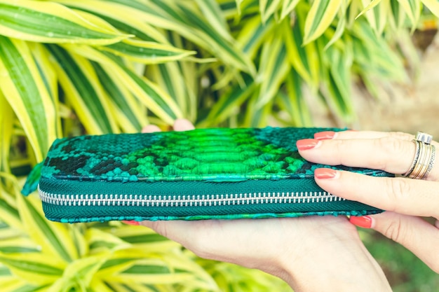 A close-up shot of a fuchsia silk blouse next to an emerald green velvet clutch on a marble surface, highlighting the rich textures and vibrant colors.