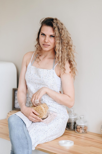 A woman with long, wavy hair wearing a low ponytail secured with a neutral-colored linen scrunchie. She is dressed in a flowy bohemian-style dress, illustrating how the scrunchie can blend seamlessly with a relaxed and earthy aesthetic.