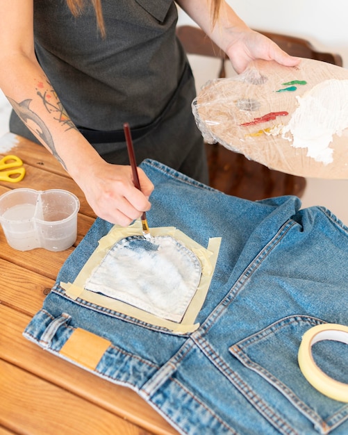 A person wearing a creatively upcycled denim jacket, showcasing patchwork designs and unique embellishments, demonstrating how to transform old items into trendy treasures for sustainable style.