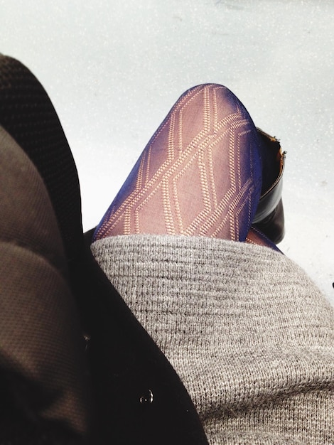 A close-up shot of a woman's legs showcasing high-waisted leggings made of a textured, high-performance fabric. The leggings have subtle design details such as mesh panels and reflective accents.
