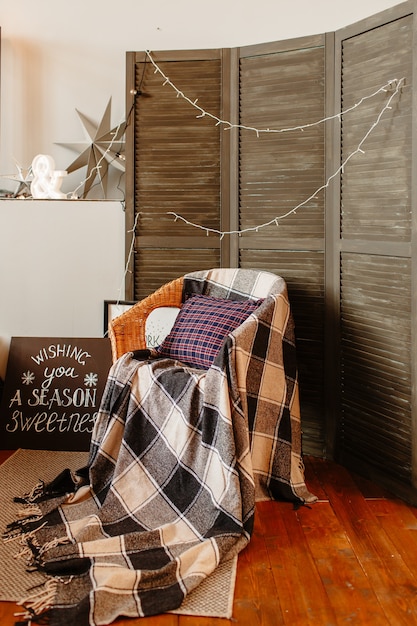 A cozy corner in a living room featuring a repurposed vintage suitcase as a side table, topped with a lamp with a custom comic book lampshade. The corner also includes a thrifted armchair with a throw pillow made from a vintage band t-shirt, creating a unique and eco-friendly pop culture-inspired space.