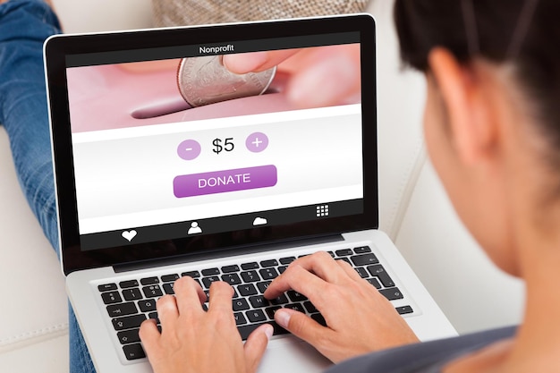 A close-up of a browser extension icon on a computer screen, with a small notification bubble showing a discount percentage, and the background blurred with popular shopping websites.