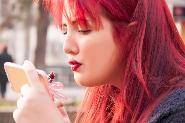A person using a mobile app to virtually try on different shades of lipstick. The app accurately overlays the lipstick on their lips, allowing them to compare different colors and finishes.