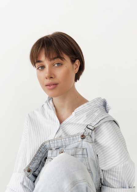 A woman sporting a chic blunt bob haircut with a center part. She is wearing a minimalist outfit and is photographed against a plain white background to emphasize the haircut's clean lines.