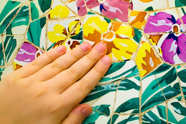 A close-up of nails featuring intricate floral designs with tiny, detailed flowers in various colors, set against a soft, pastel background, showcasing the artistry and delicacy of the designs.